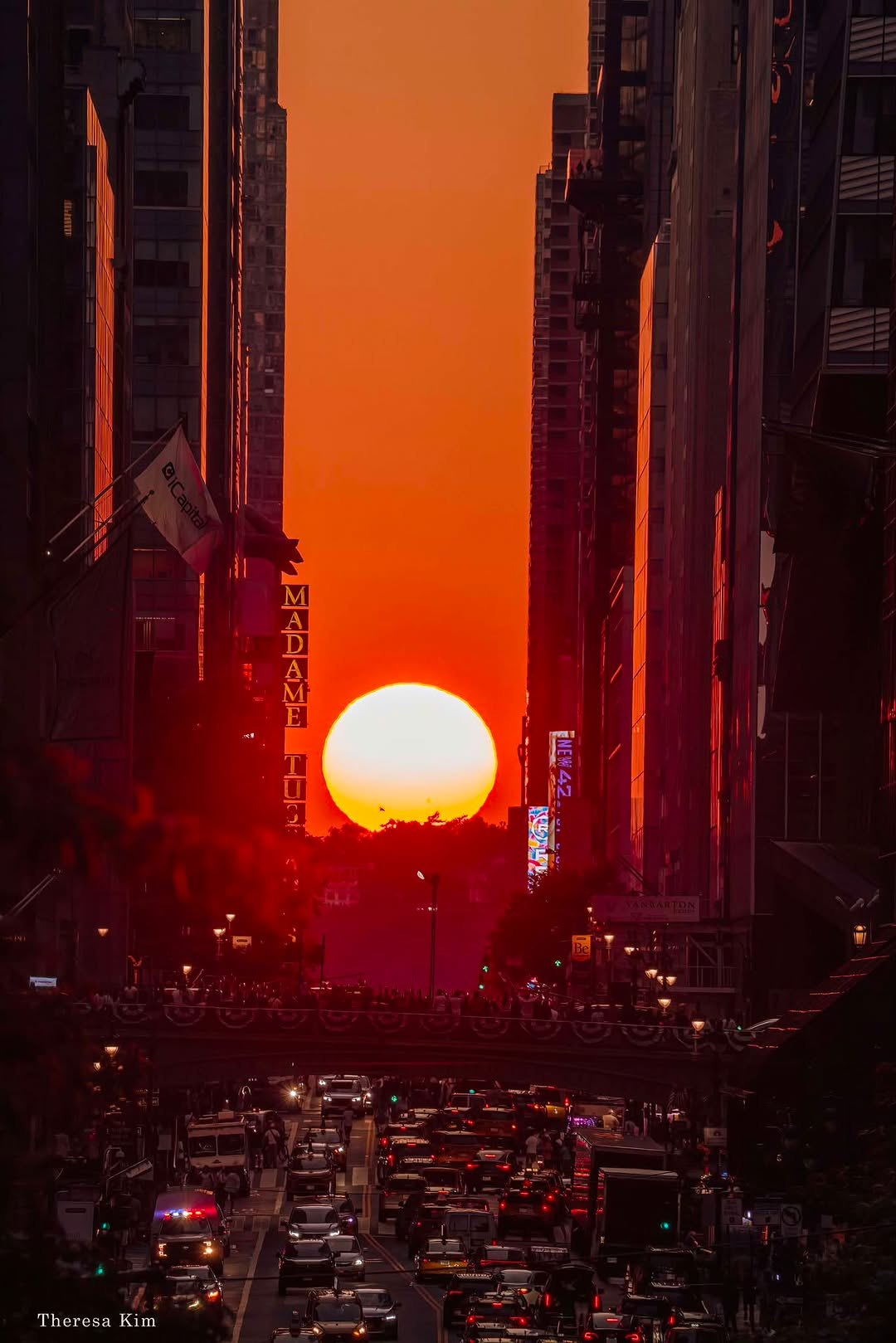 Setting sun aligned down a Manhattan street canyon, glowing between buildings