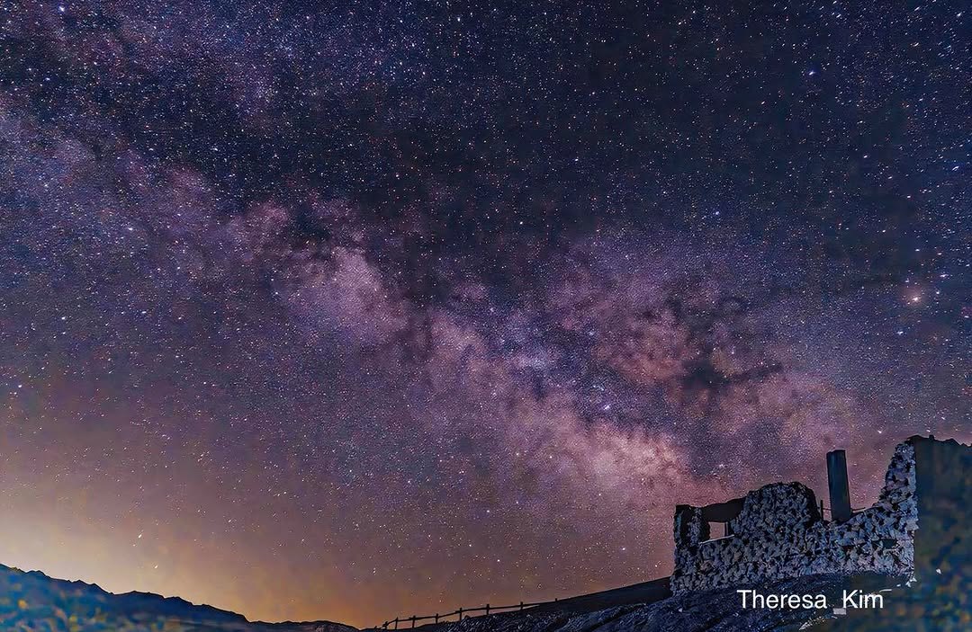 Milky Way arcing over a stone ruin in the desert night